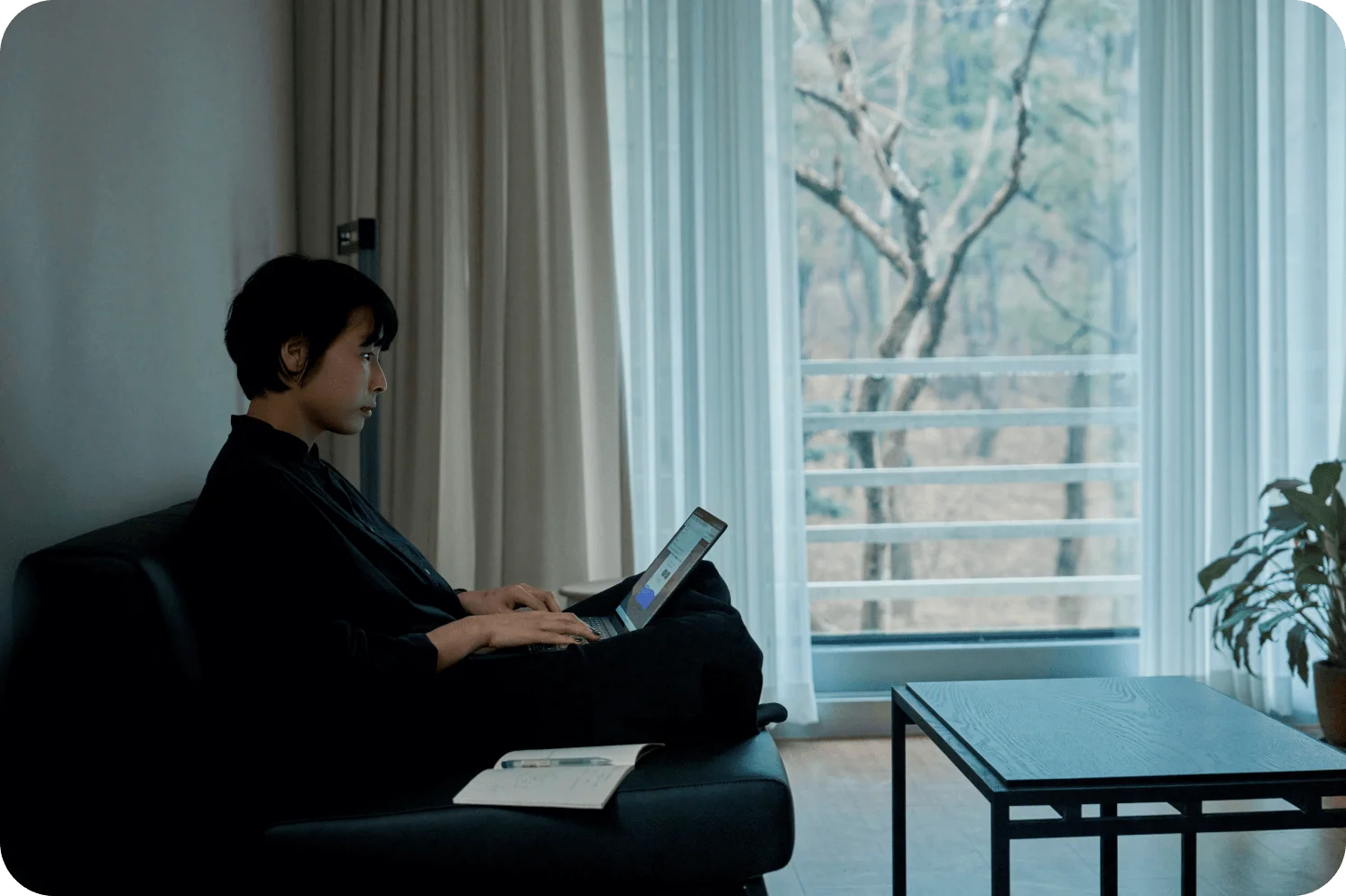 거실에서 노트북으로 디자인 작업을 하는 김동휘 디자이너의 옆모습