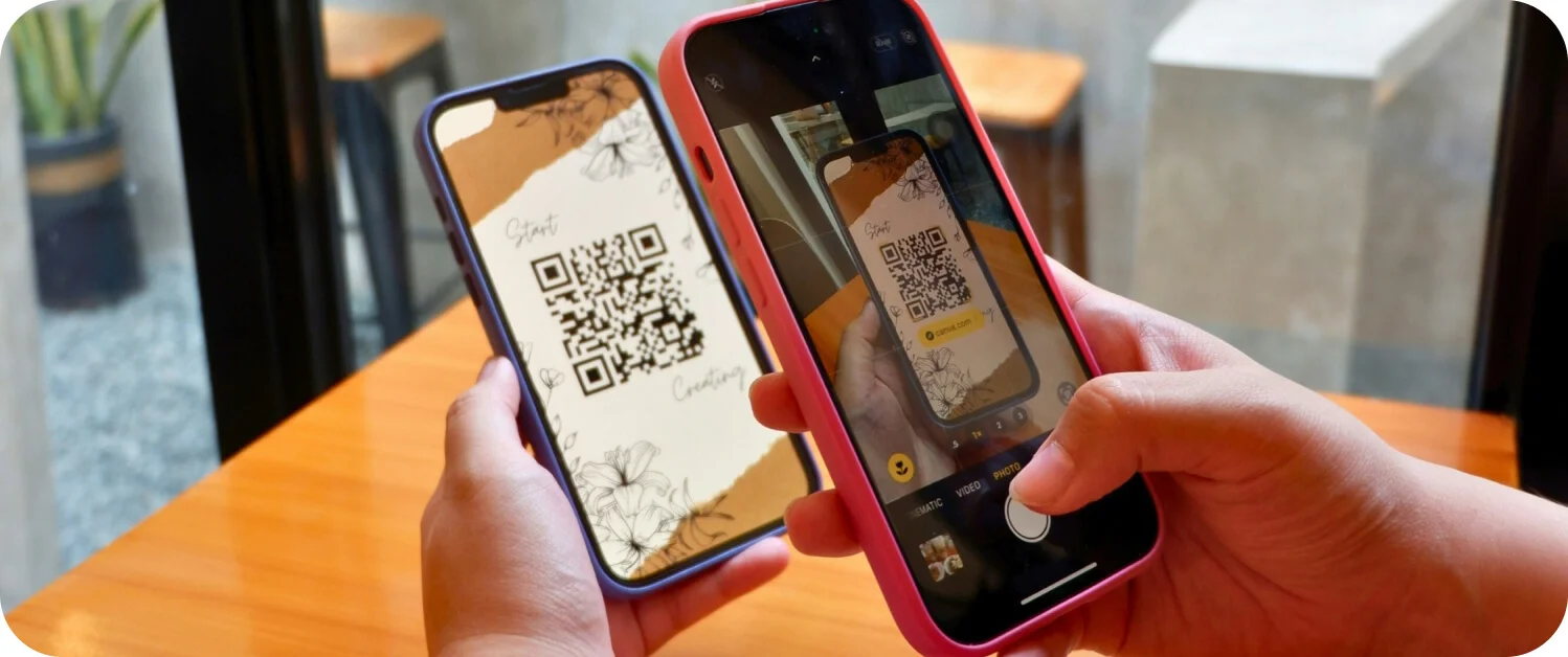 핸드폰으로 QR코드를 찍어보고 있는 이미지